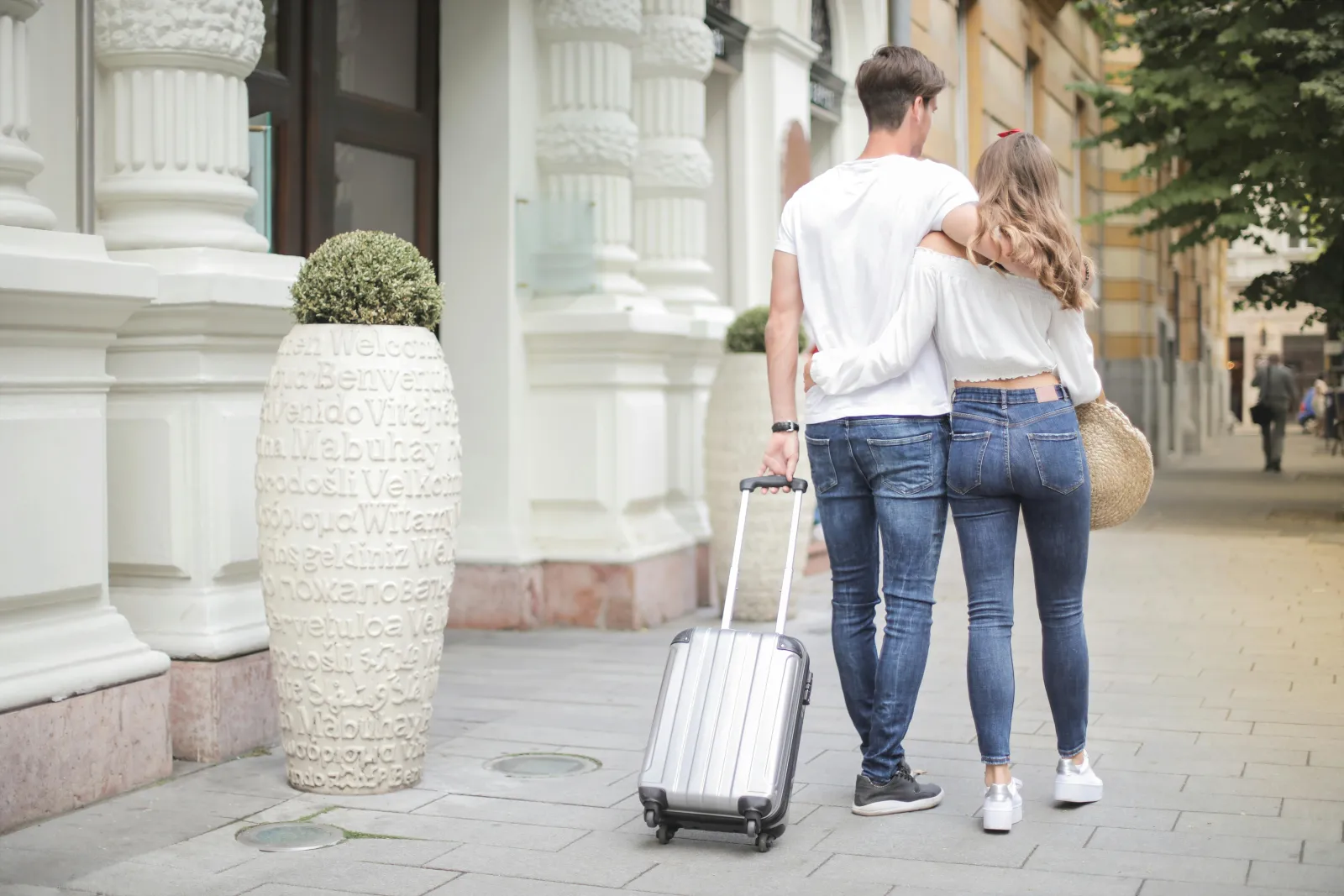 Par med kofferter på vei ut døren, klare for reise