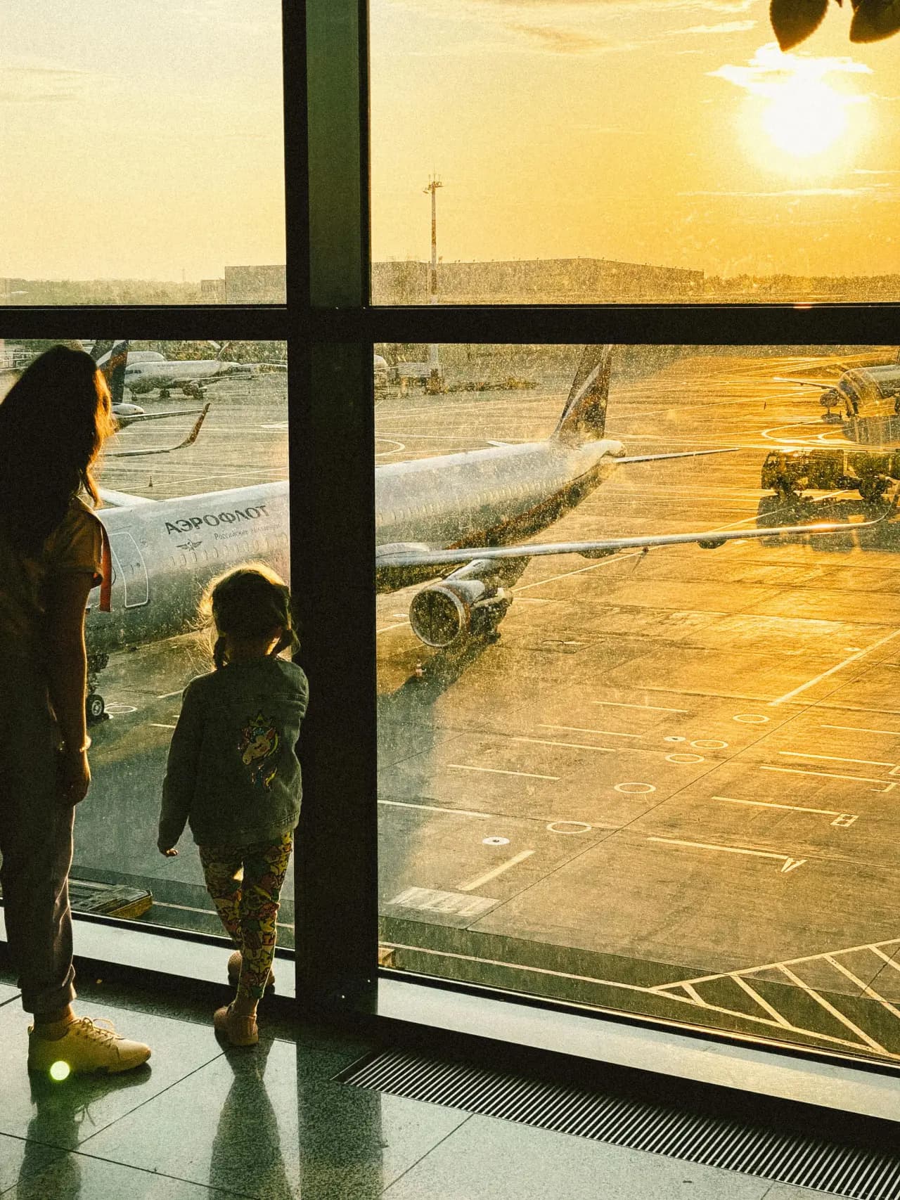 Silhuett av en person som ser på fly i en gyllen soloppgang